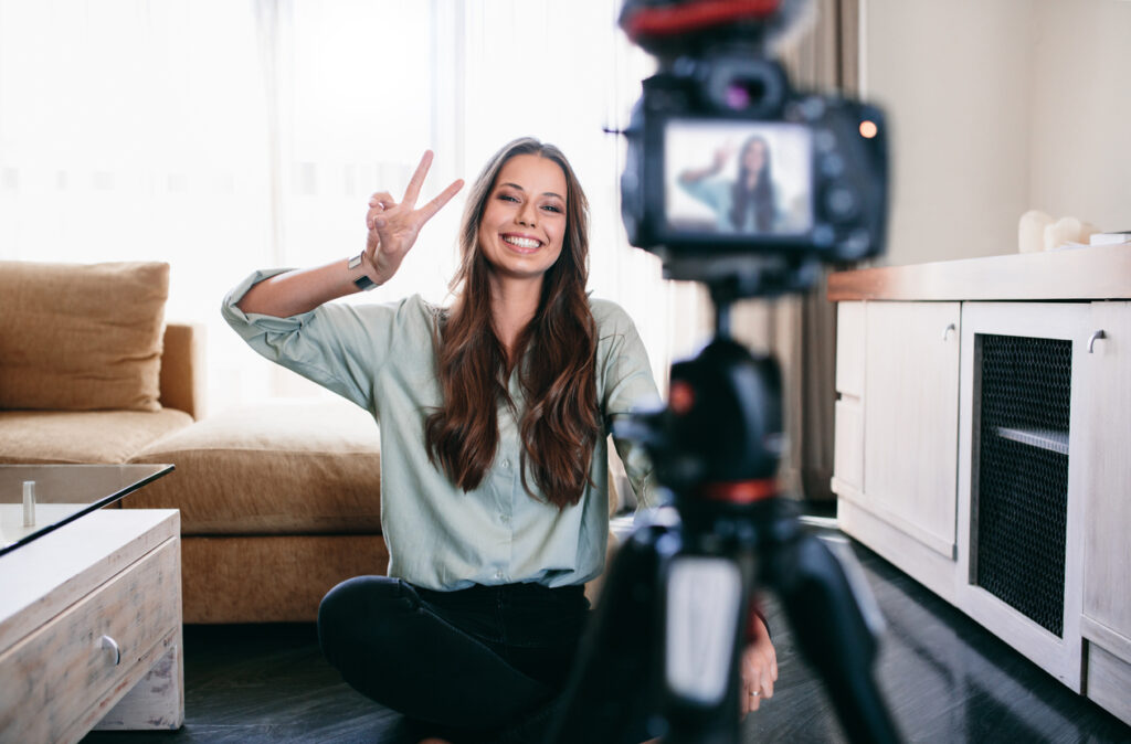A female vlogger filming a video for her new content in the living room.